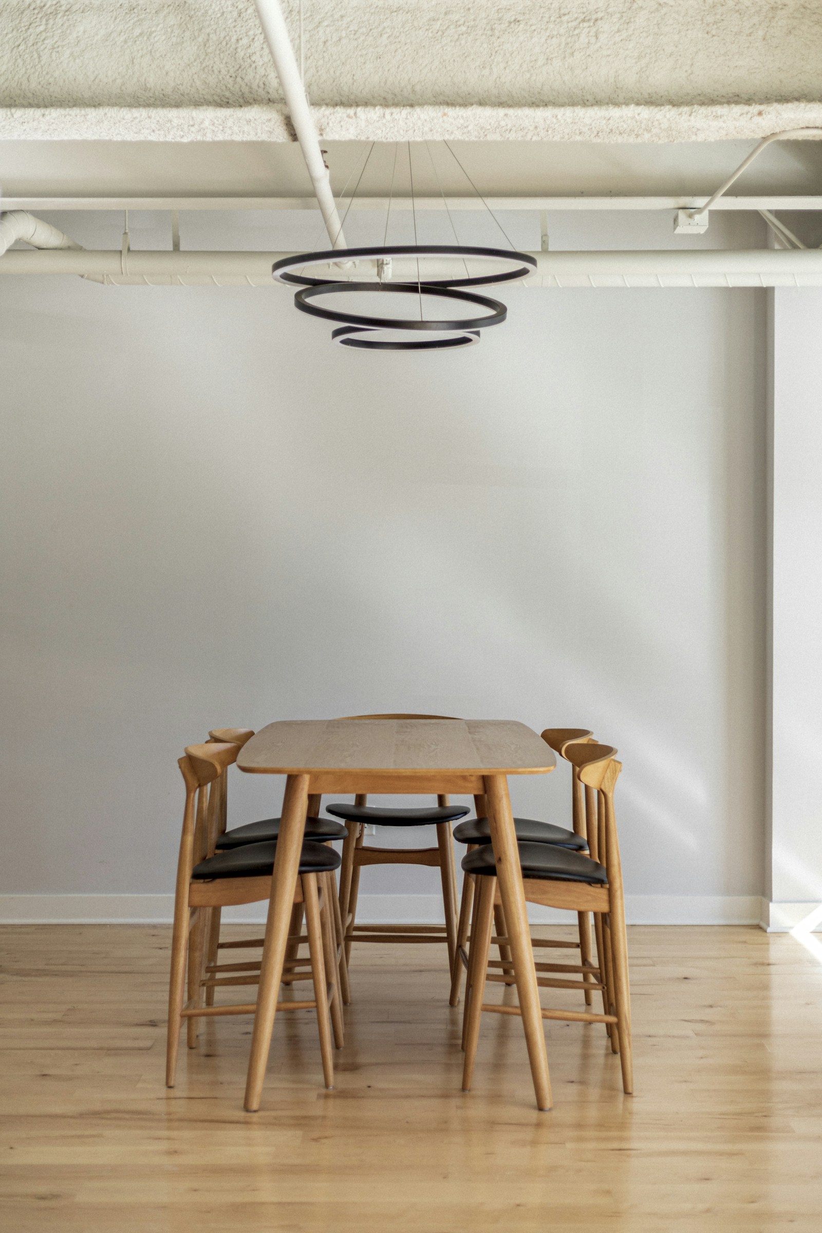 Esszimmer mit Holztisch, Stühlen und warmem Pendellicht